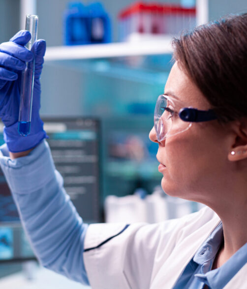 Healthcare medicine scientist doctor looking at chemical sample expertise. Pharmaceutical biotechnologist in research laboratory works with test tube to find vaccine glove.